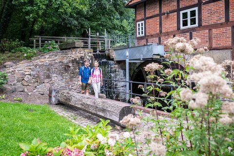 Wanderer an einer Wassermühle