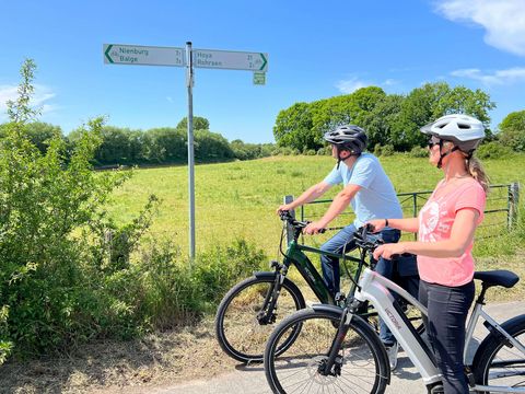 Zwei Radfahrer schauen auf die Radwegweisung